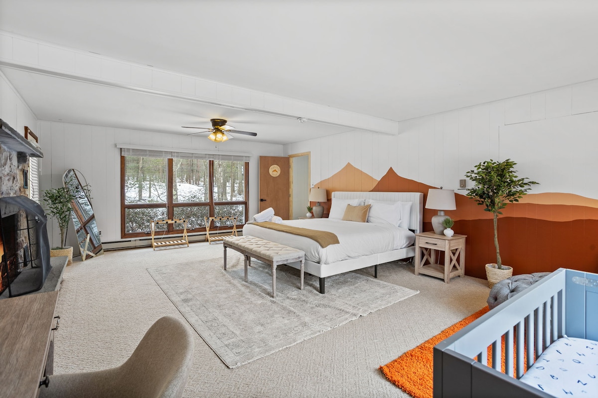 Ein verträumtes Schlafzimmer mit Kamin, gemütlicher Bettwäsche und eleganter Einrichtung, entworfen für ultimative Entspannung.