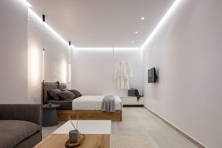 Moderna spavaća soba otvorenog tipa s blagim LED osvjetljenjem i umirujućim neutralnim tonovima. Elegantan prostor osmišljen za potpuno opuštanje.
