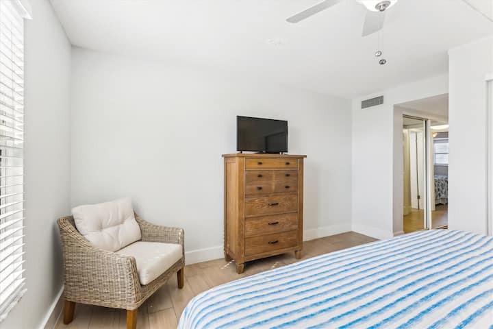 - 主寝室には、籐風のドレッサー、快適な読書用チェア、壁掛けテレビが備わっており、リラックスできます
-窓から柔らかな光が差し込み、明るく風通しの良い雰囲気を作り出しています
- 完全に荷物を解いて落ち着けるスペースで、快適にくつろぎましょう