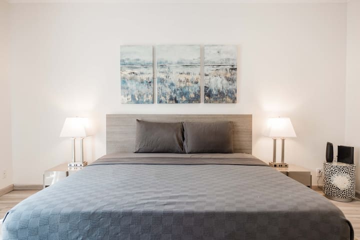 Cama king size e iluminação ambiante para o quarto principal.