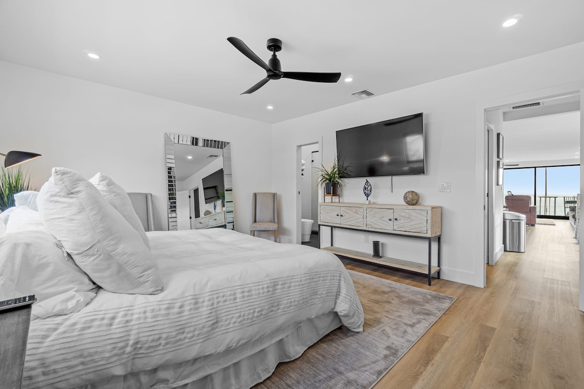 Dhoma ka një krevat të madh me shtroja të bardha, një komodinë elegante poshtë një televizori të montuar në mur dhe një ventilator të lëmuar në tavan të zi. Një pasqyrë me gjatësi të plotë mbështetet në një mur, duke shtuar funksionin dhe një prekje glam.