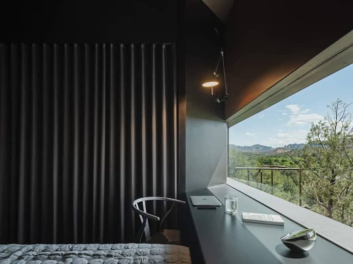 Comfortable bedroom with a dedicated workspace and scenic views.
