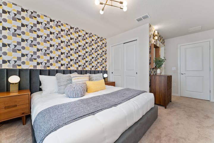 Vitajte v tejto krásne navrhnutej spálni, kde štýlová vzorovaná tapeta a mäkká neutrálna posteľná bielizeň vytvárajú útulnú atmosféru. Tento priestor s teplými drevenými prvkami na nočných stolíkoch vám sľubuje pokojné a príjemné noci.