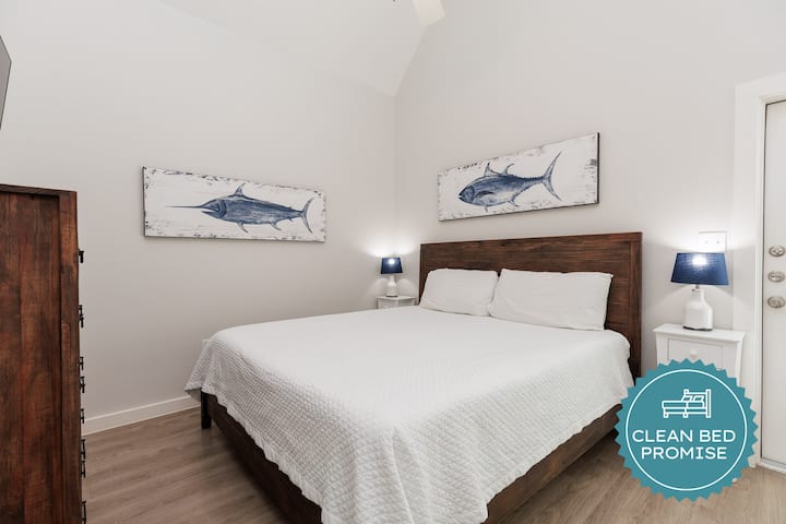 Duerme plácidamente en tu habitación de inspiración costera, equipada con obras de arte náuticas y una acogedora iluminación junto a la cama.