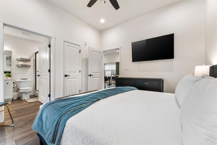 Esta suíte principal com cama king size, localizada no andar principal, oferece acesso conveniente, uma cama confortável e uma TV privativa para maior relaxamento.