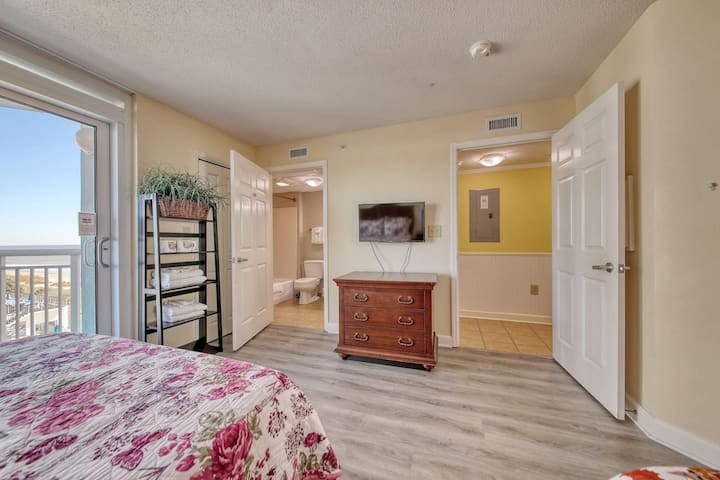 חדר שינה מואר ונעים עם מצעים פרחוניים, טלוויזיה וגישה נוחה למרפסת לנופים מדהימים. פריסה מרווחת עם חדר רחצה מחובר מציעה נוחות ונוחות.