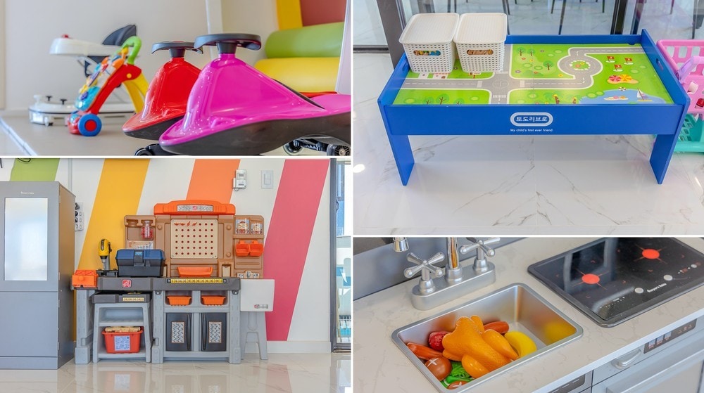 A bright play area is featured with colorful activity toys, including ride-on cars and a road-themed play table. A miniature kitchen setup displays various utensils and food items, while a modern kitchen offers a clean view of sinks and playful food replicas.