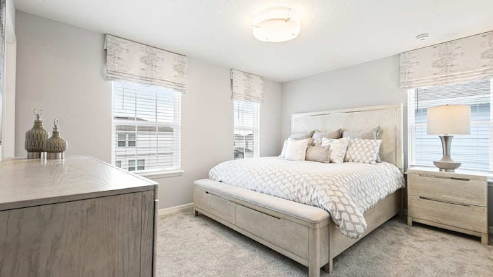 Elegante slaapkamer met zachte neutrale kleuren, zacht beddengoed en veel natuurlijk licht!