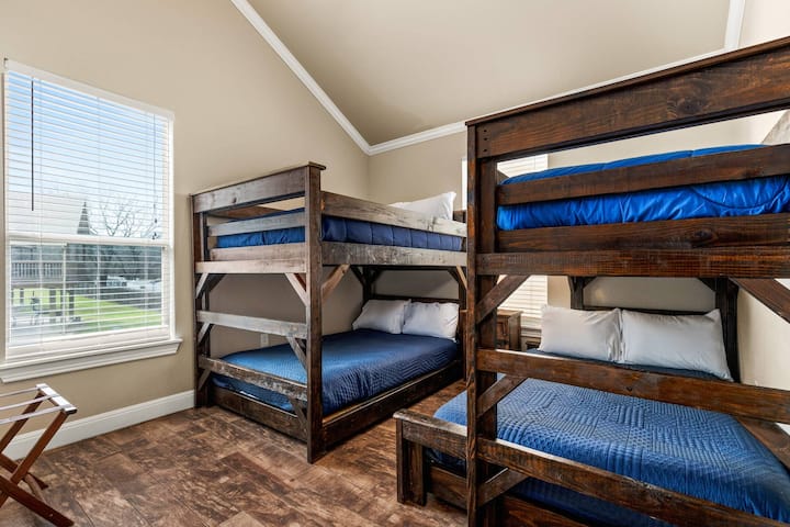 Upstairs guest rooms are thoughtfully designed with both fun and functionality in mind, featuring twin bunk beds and a versatile combo bunk bed.