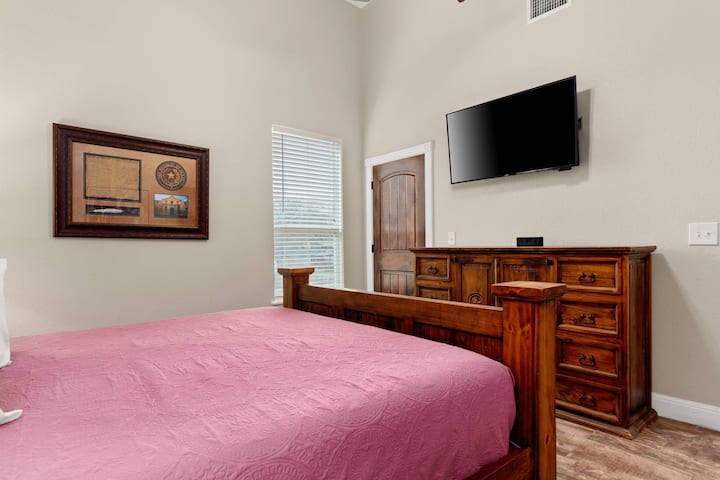Experience the epitome of comfort in the primary bedroom, featuring a king bed, an oversized dresser, and a Smart TV.