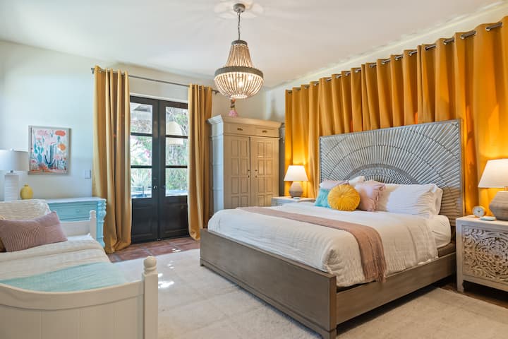 Bedroom 2 features a king bed, a twin-size daybed, a TV, and outdoor access.