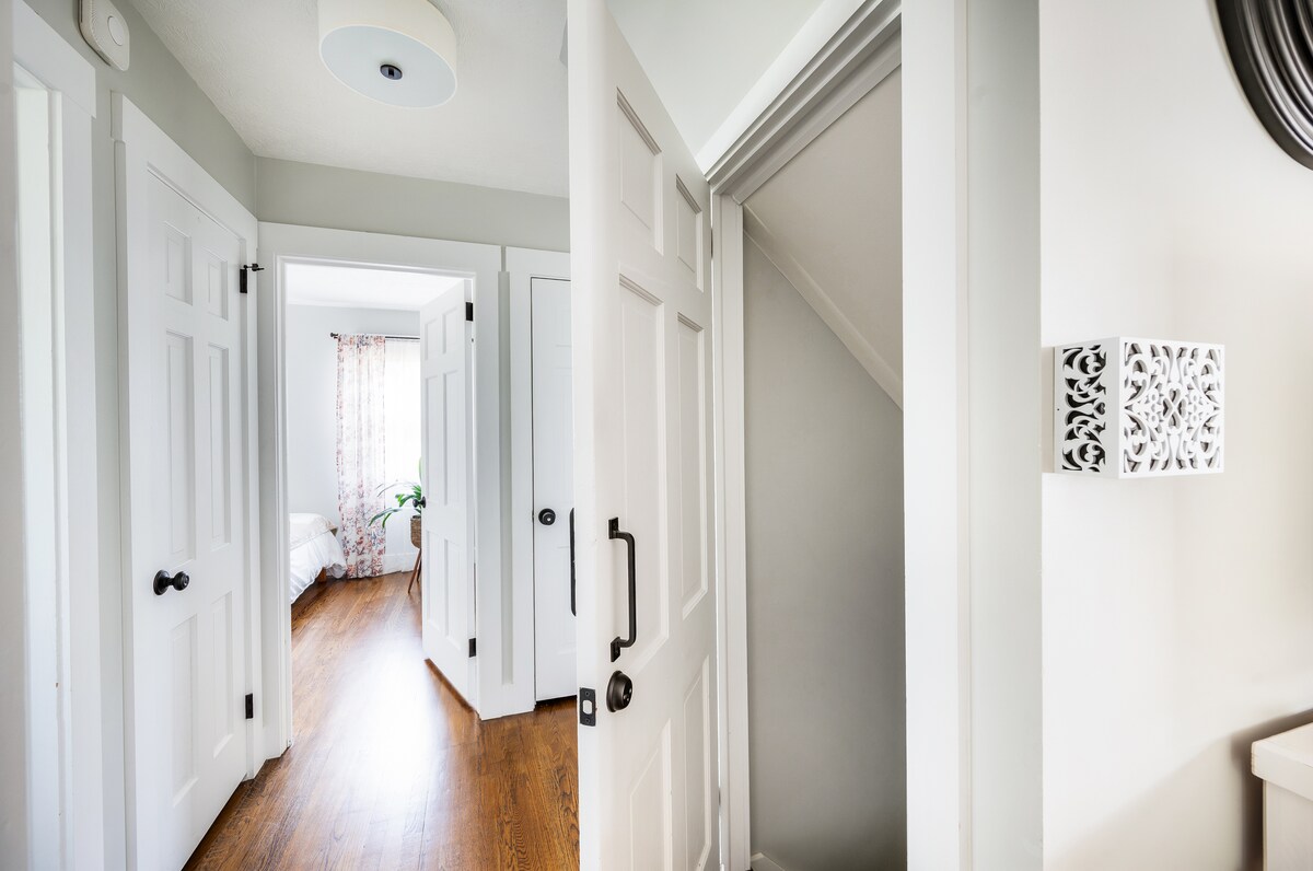 View from living room into bedroom #1 and to the right the view of INTERIOR entry door to the fully finished basement - where you'll find a large bedroom, full bathroom, and living area/kitchenette 