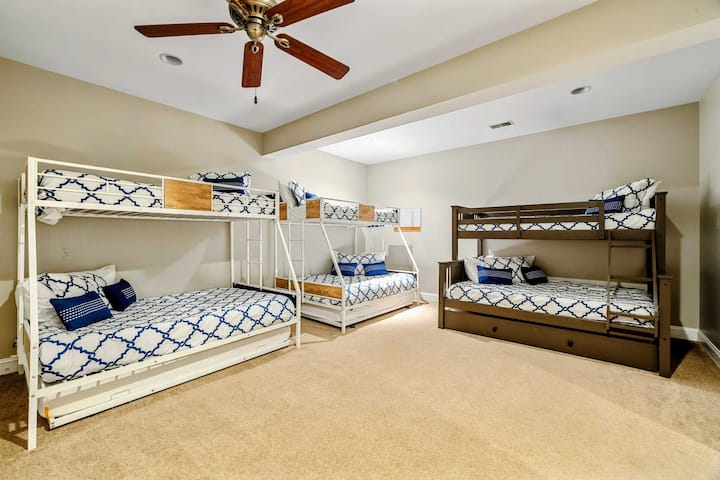 Habitación con literas: tres literas (dos de una plaza sobre una de plaza y media, y una de una plaza sobre otra de una plaza con cama nido) con capacidad para todo el grupo, con ropa de cama coordinada en azul y blanco.