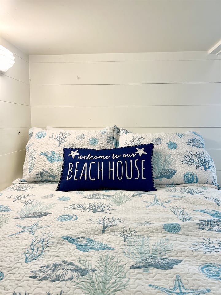 Chumba cha 2 cha kulala cha Beach Breeze: Chumba cha ghorofa, bora kwa familia, wageni wa vijana na kulala 8. Droo chini ya maghorofa na kifua cha kuhifadhi kinachopatikana chini ya televisheni.