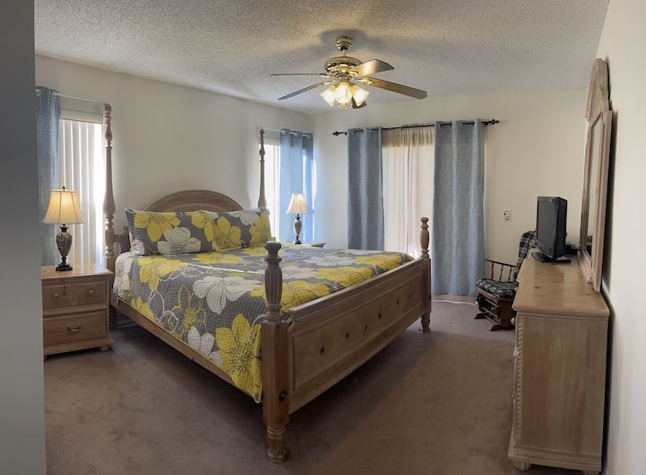 חדר שינה ראשי עם טלוויזיה עם מסך שטוח ואמבטיה צמודה מציע מקום מפלט מפואר ופרטי המיועד לנוחות ורוגע.