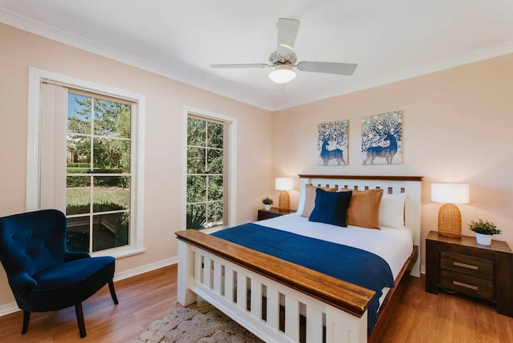 El cuarto dormitorio cuenta con una estructura de cama tamaño queen de madera atemporal, grandes ventanas a la sombra, lámparas cálidas de noche y almacenamiento para guardar tus pertenencias. 