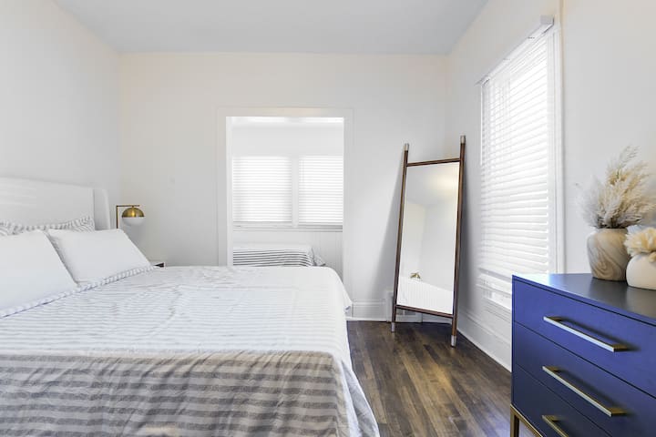 Main level bedroom with one queen bed and additional single bed in attached room