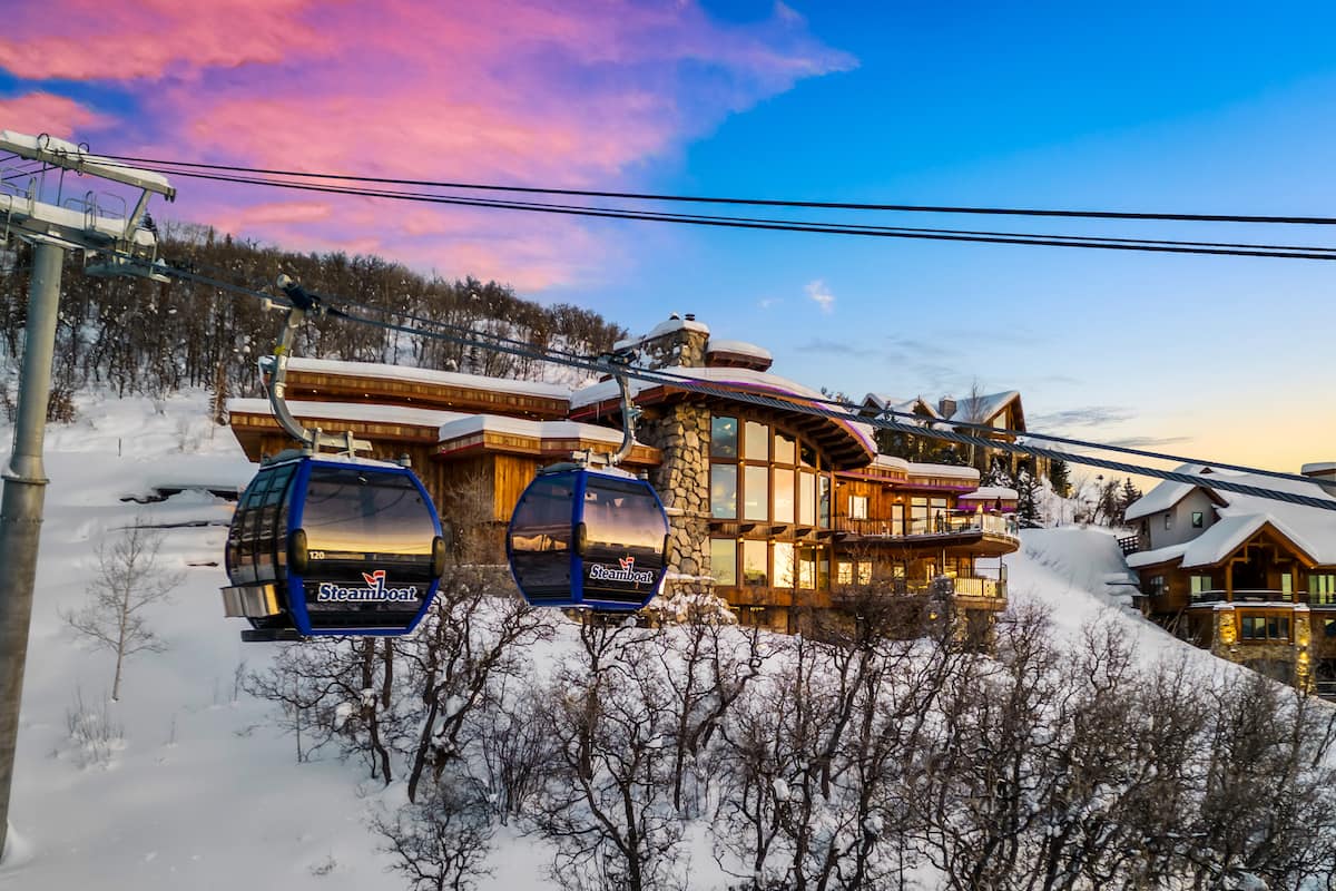 Cowboy Lodge exterior at dusk with Steamboat Resort gondola in the background