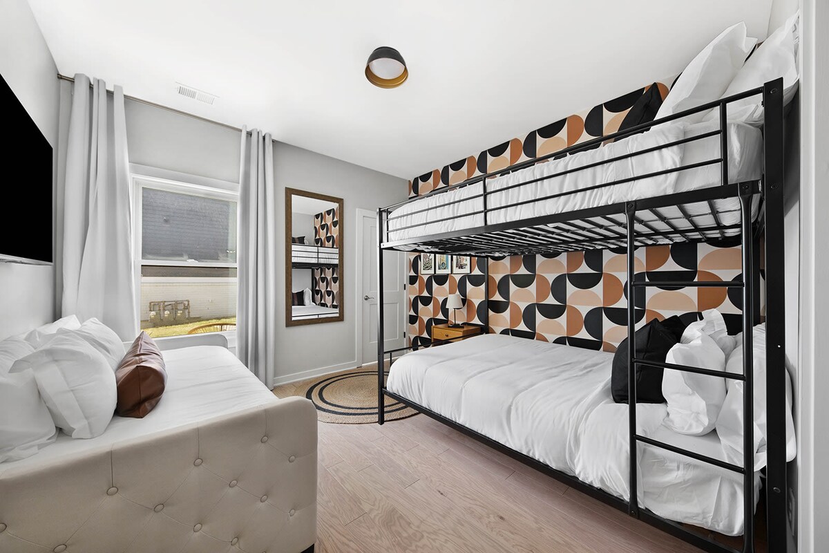 חדר הקומתיים בקומה הראשונה כולל מיטת קומתיים עם שתי מיטות קווין סייז, מיטה זוגית עם מיטה זוגית נוספת וטלוויזיה חכמה המותקנת על הקיר לבידור.