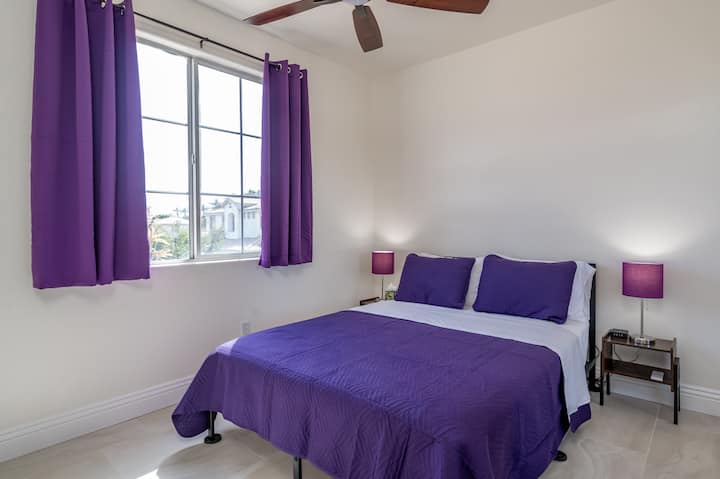 Queen bed, charging station, nightstands, and lamp