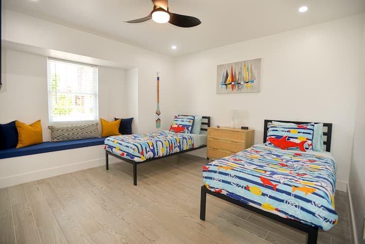 Bright, cheerful, and kid-approved — a playful bedroom with twin beds and a cozy window seat, perfect for little travelers to unwind after a day of Florida adventures