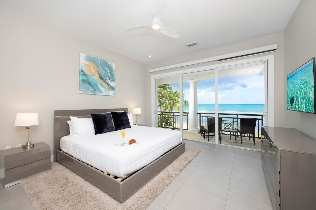 El dormitorio 1 tiene una cama tamaño king, TV de alta definición y acceso a un balcón compartido con vista al mar. 