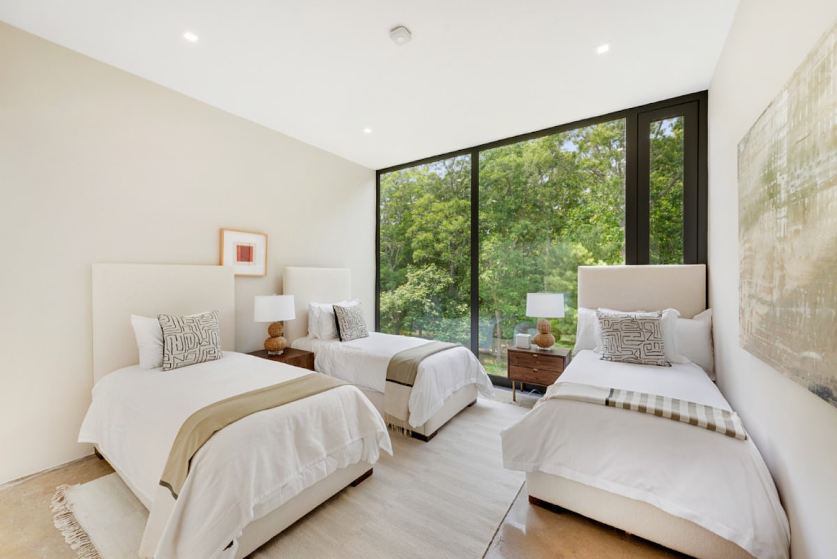 Pumzika katika oasis tulivu ya chumba cha kulala, iliyofunikwa na mashuka laini na taa laini, inayofaa kwa wale wanaotafuta mapumziko ya amani na mapumziko kutoka kwenye shughuli hiyo.