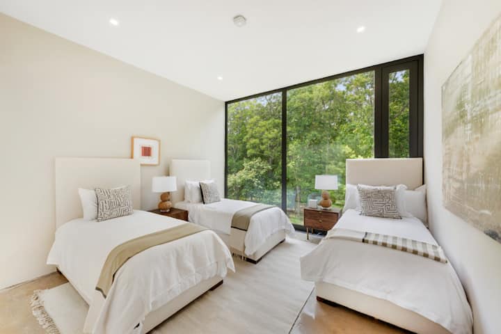 Unwind in a serene bedroom oasis, enveloped in soft linens and gentle lighting, perfect for those seeking peaceful relaxation and a break from the hustle.