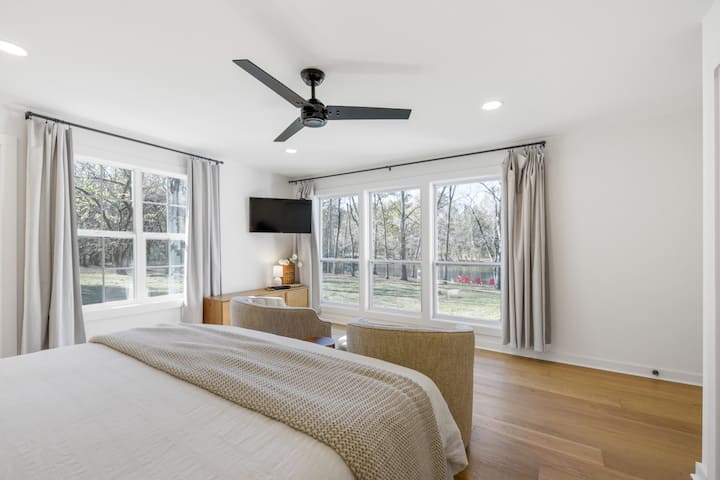 Dormitorio principal con vistas al lago y baño privado con ducha y bañera independiente.