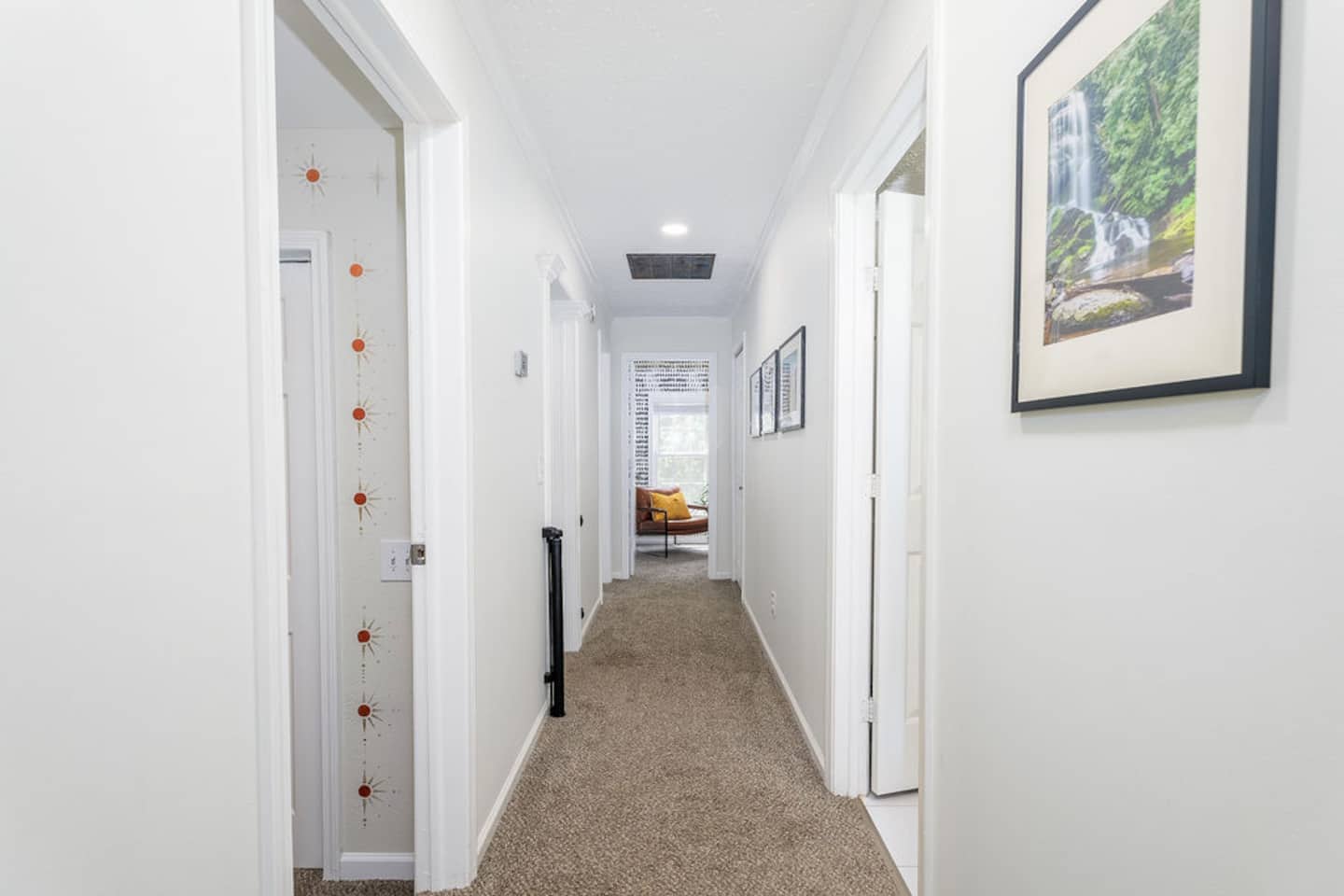 You'll cross this upstairs hallway to reach four of your six bedrooms, baby gate included for the littlest guests