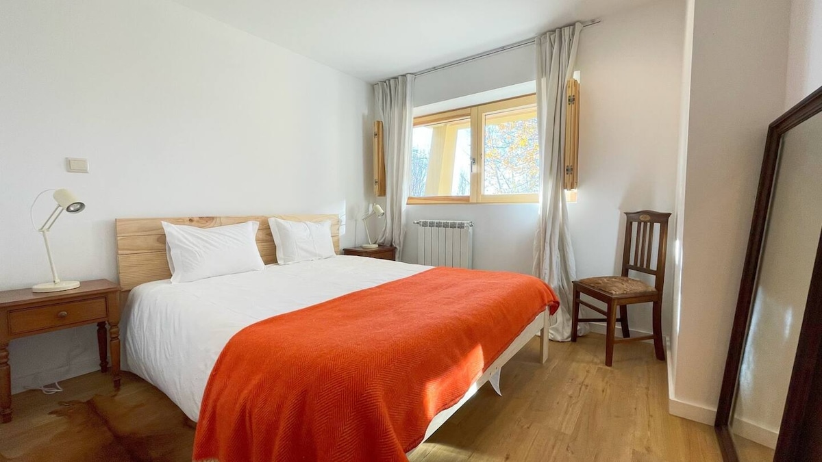 ห้องนอนใหญ่มีเตียงคู่ที่สะดวกสบายหน้าต่างบานใหญ่พร้อมแสงธรรมชาติและการตกแต่งที่เรียบง่ายและผ่อนคลาย 