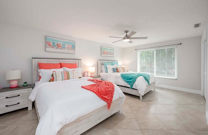 Spálňa pre hostí s dvoma manželskými posteľami veľkosti Queen a výhľadom do záhrady