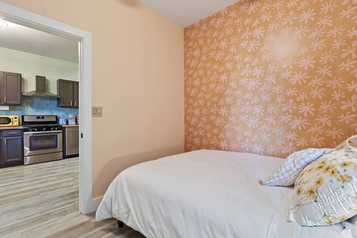 Enjoy a peaceful night's sleep in this cheerful bedroom, just steps away from the kitchen—perfect for late-night snacks or slow mornings.