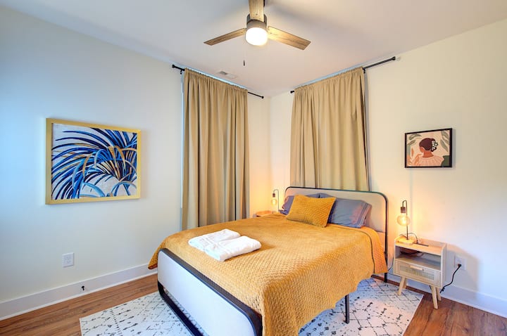 Descansa con estilo: dormitorio Queen con lujosa ropa de cama dorada, cortinas opacas, iluminación suave y sábanas de primera calidad para un sueño profundo y reparador