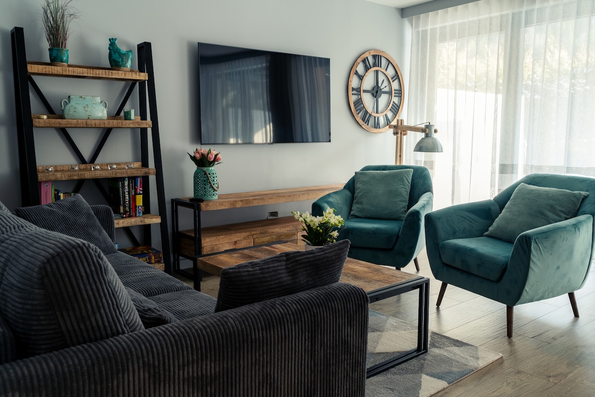 Sala de estar con sofá plegable, TV y salida a la terraza