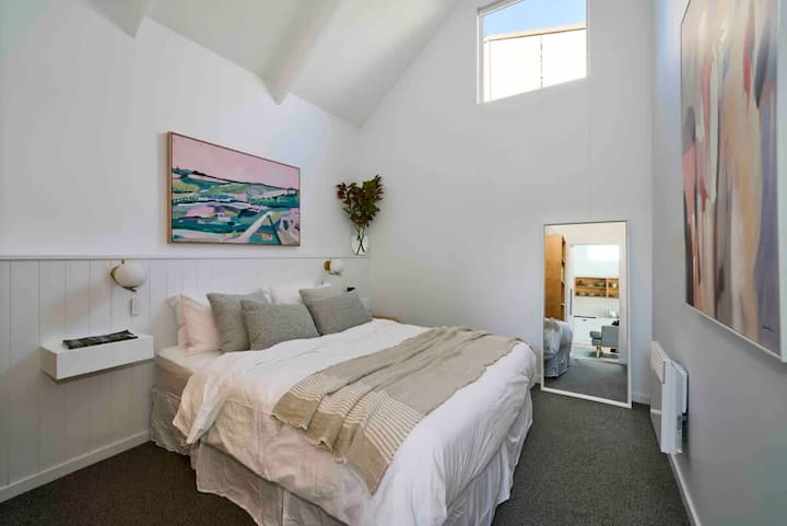 Bedroom 2 with queen bed, full length mirror, electric heater and wardrobe.