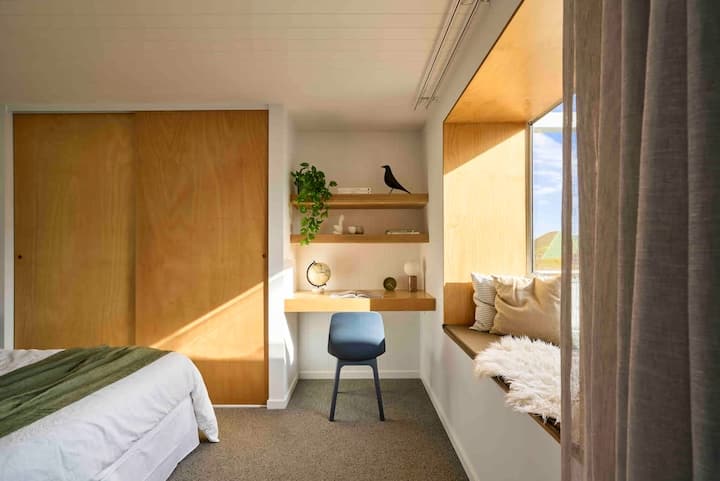Bedroom 1 with queen bed, blockout curtains, wardrobes, desk and pop-out window.