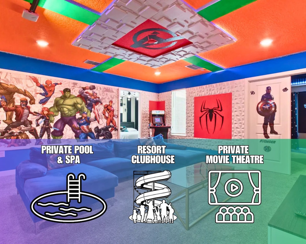 A vibrant game room features colorful walls adorned with superhero murals. A plush seating area is positioned for comfort, and a big projection screen is ready for movie nights. The room is well-lit, enhancing its inviting atmosphere for entertainment and relaxation.