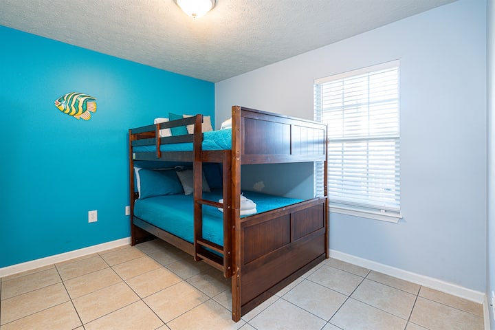 chumba cha kulala cha watoto kilicho na vitanda vya ghorofa na skrini tambarare ya televisheni