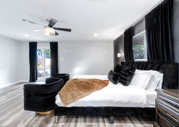 Contemporary comfort in every corner: Twin black chairs add a touch of elegance to this cozy bedroom retreat.