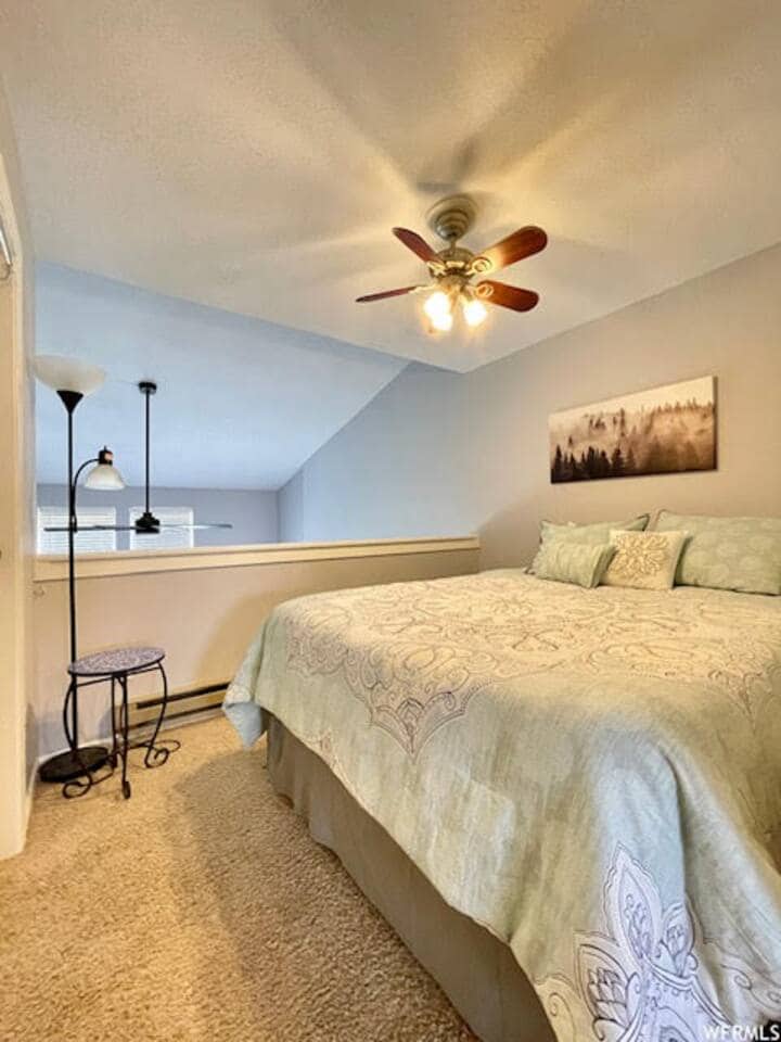 Chumba cha kulala cha roshani kina feni ya dari na mwanga mwingi wa asili. 