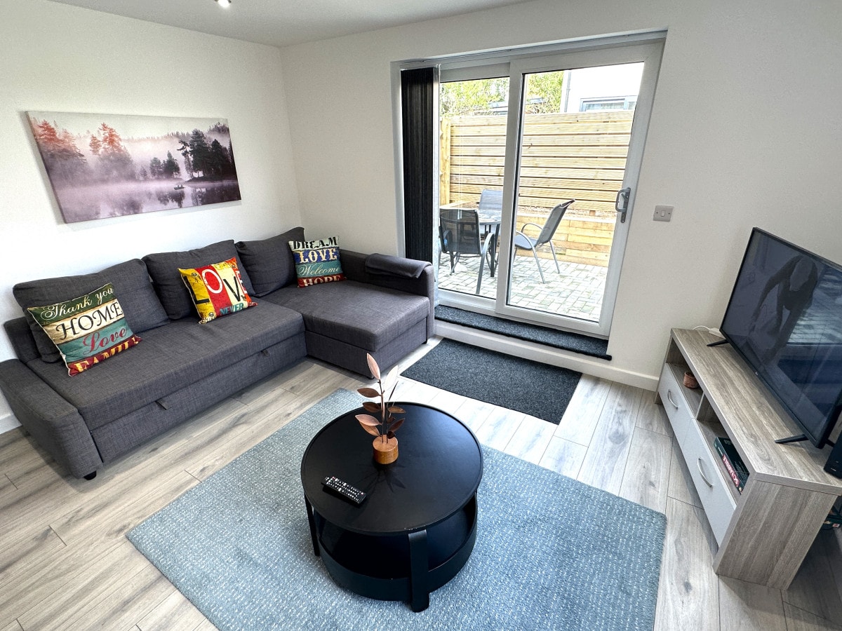 סלון, טלוויזיה חכמה עם נטפליקס, ספה נפתחת, דלת פטיו לכיוון הגינה הצדדית. מנוהל באופן מקצועי על ידי : GPSbnb