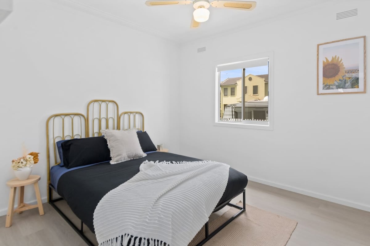 The sunny second bedroom features a lovely queen-sized bed and ceiling fan to keep temperatures comfortable.
