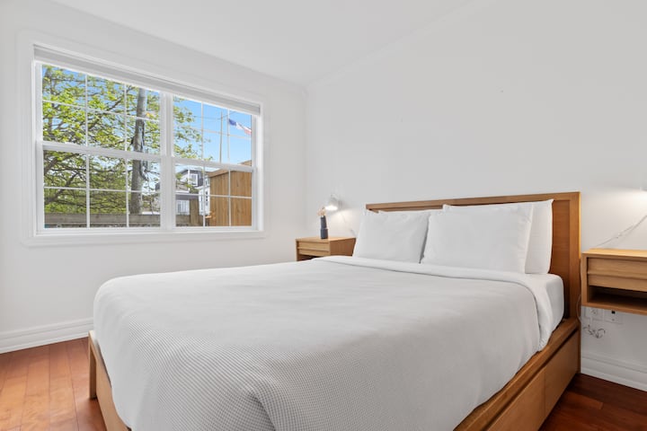 להירגע בחדר השינה הנעים והמואר הזה - עם מיטה זוגית מפוארת, מצעים לבנים נקיים ונוף שליו דרך החלון הגדול!