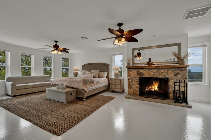 Chumba kikuu cha kulala kina kitanda cha kifalme na meko ya mawe.