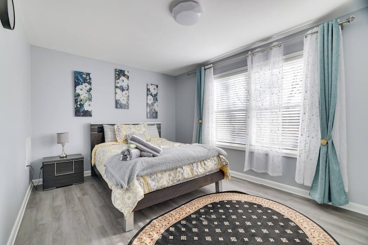 A room with a view! This spacious bedroom features large windows that let in plenty of natural light with fresh linen