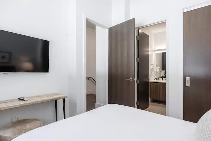 - Dormitorio de invitados con TV de pantalla plana y escritorio de madera moderno  
- Acceso directo al baño con un elegante tocador y espejo  
- Cómodo refugio con líneas limpias y decoración elegante