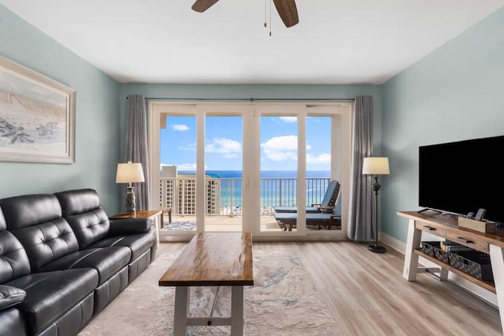 Sala de estar con impresionantes vistas al mar, TV inteligente de 55 pulgadas, sofá reclinable de cuero y acceso extragrande al balcón privado