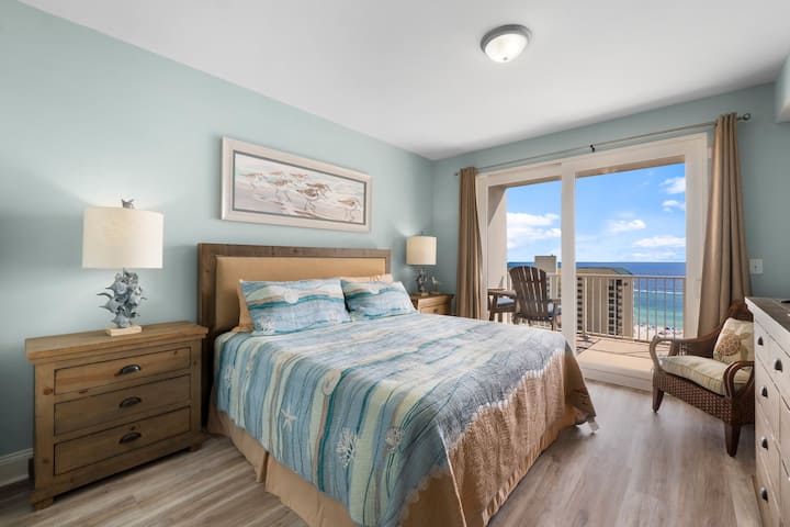 Dormitorio principal con vistas al mar, cama tamaño king, televisor inteligente de 55 pulgadas, baño privado y acceso privado al balcón