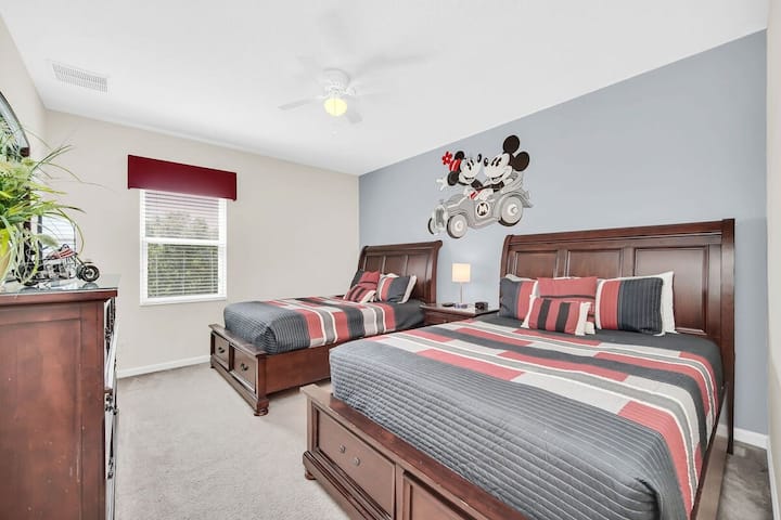 חדר בסגנון מיקי מאוס עם 2 מיטות זוגיות, מאוורר תקרה, טלוויזיה עם מסך שטוח וארון שקופיות. חדר רחצה צמוד עם מקלחת מעל אמבטיה, כיור, שירותים